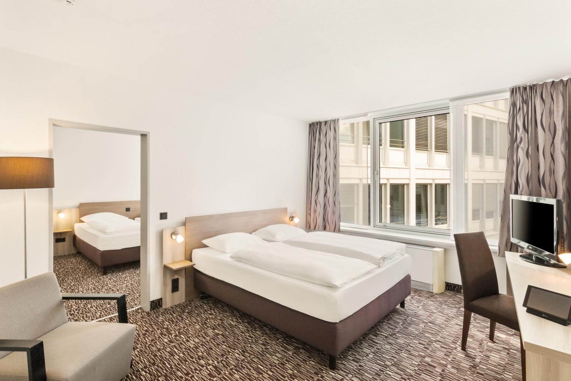 Familienzimmer mit zwei Zimmern, einem Doppelbett und zwei Einzelbetten
