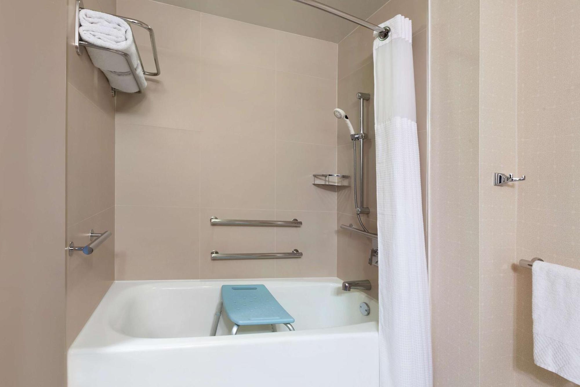 Quarto com Cama King-size, Banheira Acessível para Hóspedes com Mobilidade Reduzida e Vista da Cidade
