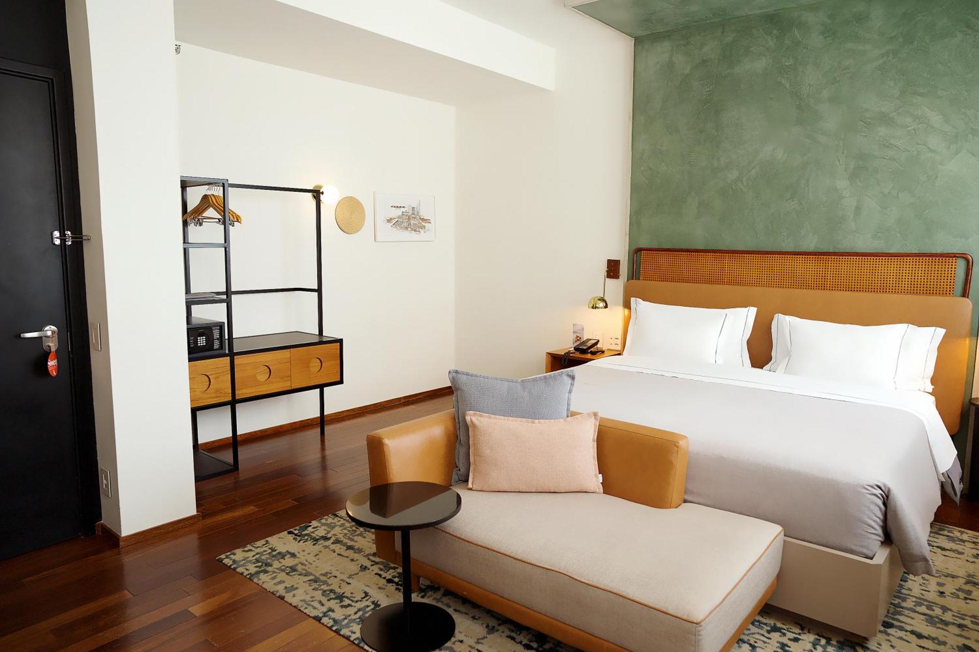 Quarto superior de canto com cama king-size e vista da cidade