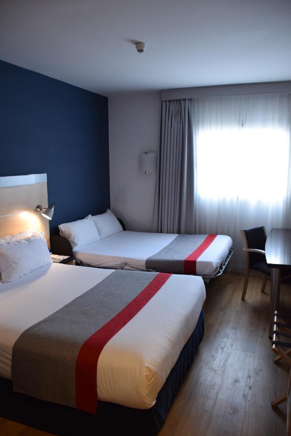 Habitación Doble Estándar con cama doble grande y sofá cama.